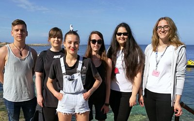 Eine Gruppe von Lehrlingen steht vor dem Meer