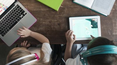 Kinder mit Kopfhörern lernen am Tablet und Laptop