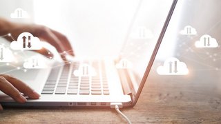 Cloud computing concept, Businessman using laptop with white clouds computing network connection and data exchange , block chain, online storage and internet communication.