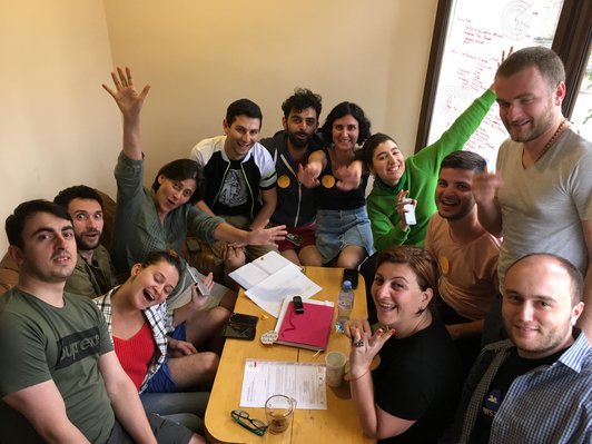 Group of people posing for a picture around a table