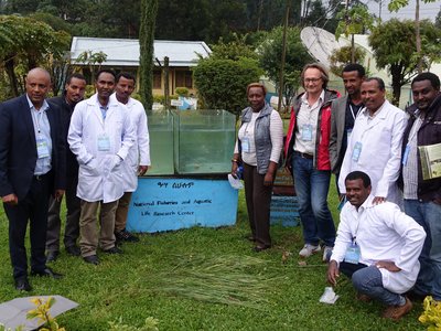 Scientists standing in the premises of the research center and posing next to aquarium 