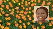 Portrait of Anne Birundi with yellow and orange tulips in the background