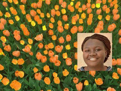 Portrait of Anne Birundi with yellow and orange tulips in the background