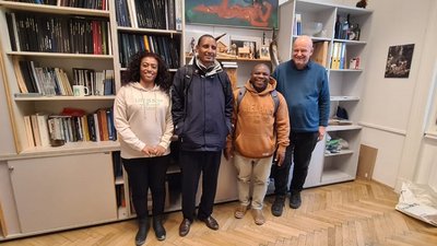 Vier Personen stehe vor einem großen Bücherregal