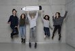 Five children jump up, one holds a large cardboard pencil in his hands.