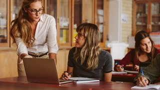 Lehrerin spricht mit Schülerin