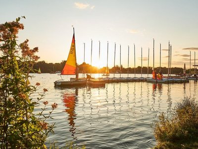 Segelboote auf einem See bei Sonnenuntergang