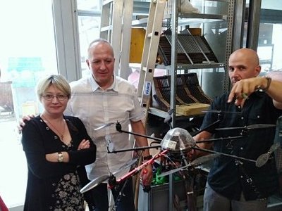 Man demonstrates a tool to three others