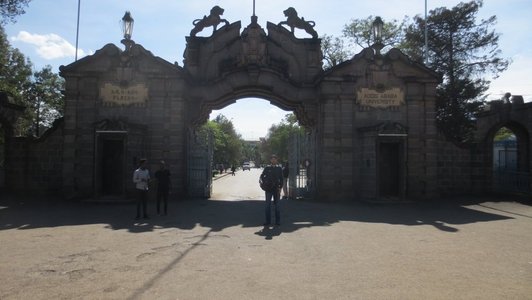 Big door in massive wall and a man standin in front of it