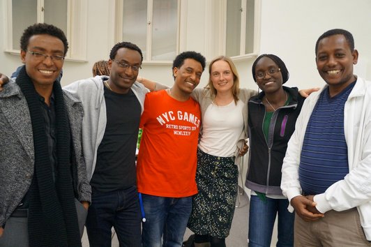 A group of six people, standing together and smiling into the camera