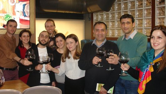 Team members raise their wine glasses to celebrate