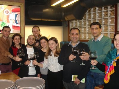 Team members raise their wine glasses to celebrate