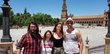  Four young people stand in front of a historic square in Málaga.