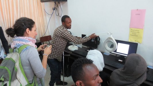 Woman looking at the white screen magnifier that a man is showing to her