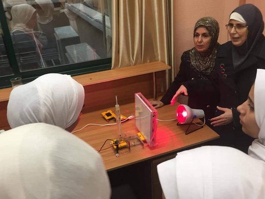 female professors demonstrate solar panel to female students