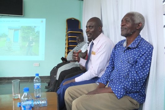 Group of man sitting next to a presentation and looking in the same direction