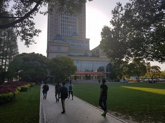 Campus of Fudan University in Shanghai: large building and extensive park with students.