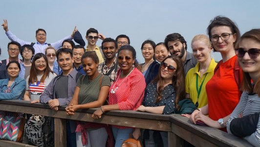 Many scholarships holders from all around the world smiling into the camera and posing for the photo