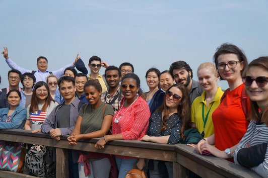 Many scholarships holders from all around the world smiling into the camera and posing for the photo