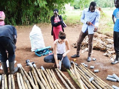 Menschen im ländlichen Setting bei der Bearbeitung von Bambusstämmen