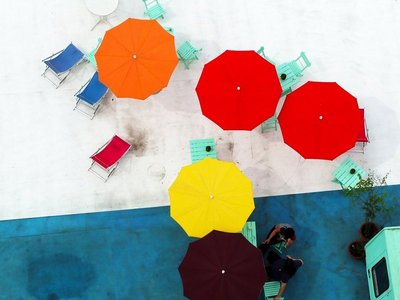 Bunte Sonnenschirme und Liegestühle auf einer Terrasse