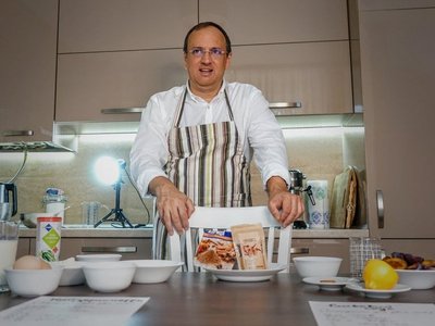 Ein Mann mit einer Kochschürze bereitet ein Rezept vor. 