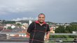 Photo of former scholarship holder on a balcony with city view