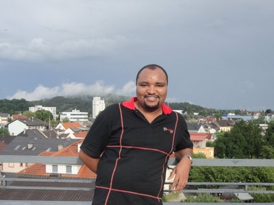 Photo of former scholarship holder on a balcony with city view