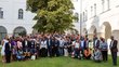 A group photo in a courtyard. The employees of Afrika-UniNet are standing on a meadow in the sunshine.