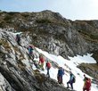 A group of hikers climbs a mountain peak