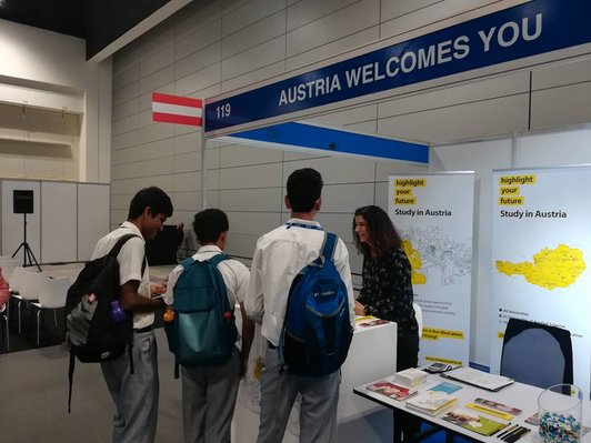 The Austrian stand at the Ghedex trade fair in Oman with three students