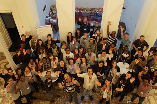 Group photo: A hall with all the event participants waving at the camera.