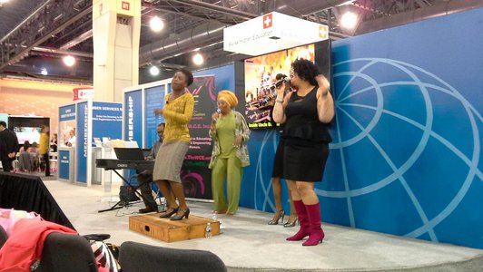 A music group plays and sings at a NAFSA trade fair stand.