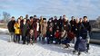 A group of students from different backgrounds stand in the snow.