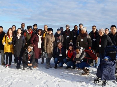 A group of students from different backgrounds stand in the snow.