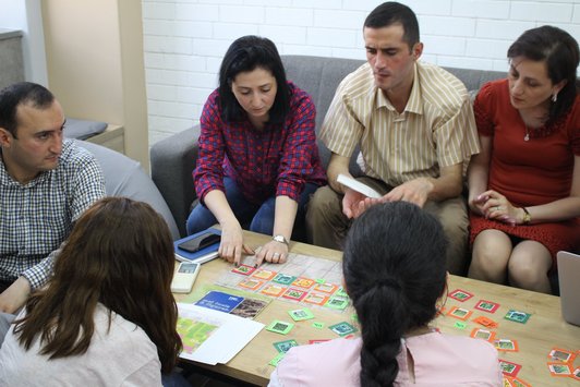 Group of people sitting around a table and work together on something