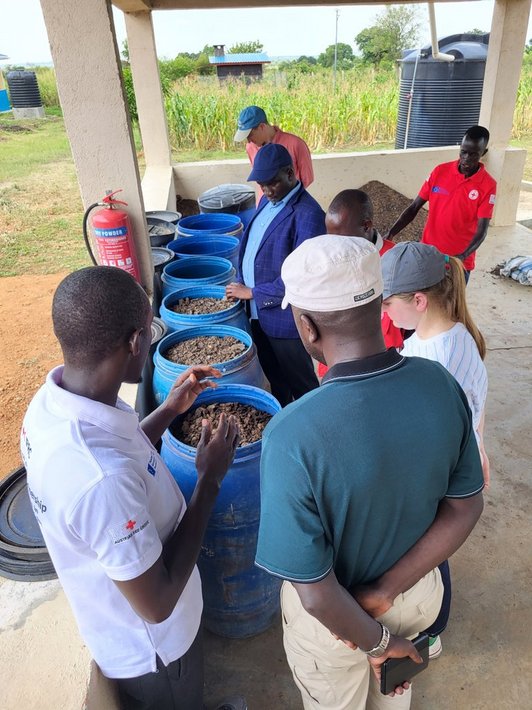 People standing around waste bins