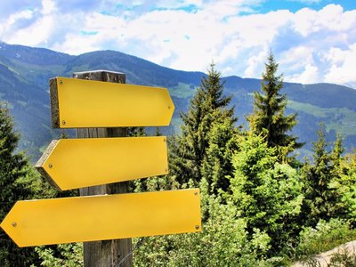 Gelbe Wegweiser in einer bergigen Landschaft