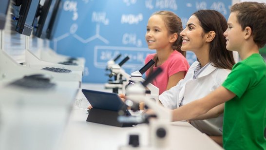 Frau zeigt Kindern Labor