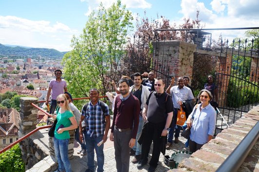 OeAD scholarship holders on the Schlossberg in Graz with a view over the city.