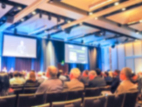 Konferenzpublikum blickt auf Bühne