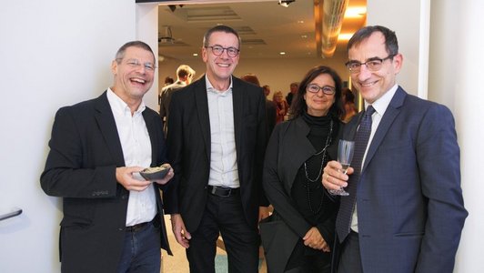 Jubiläumsveranstaltung 60 Jahre OeAD, Vier Personen stehen gemeinsam am Eingang, einer mit einem Champagner Glas.