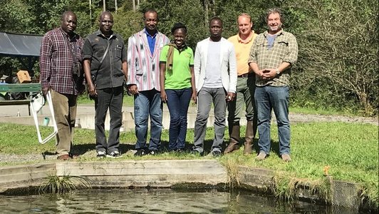 Group of people posing for a picture next to a basin