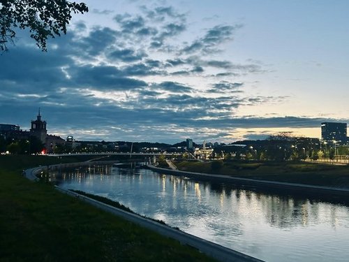 Blick auf eine Stadt an einem Fluss in der Abenddämmerung. 