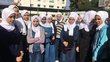 Female high school students inspect solar panel at high school yard