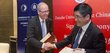 Rector of the Danube University Krems, Friedrich Faulhammer and Tong Shijun shake hands and each hold a document in their hand