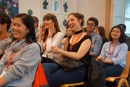 OeAD scholarship holders sit smiling in the audience.