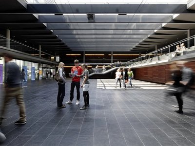 Personen gehen durch eine Halle.