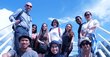 A group of ten people standing and sitting on what looks like an observation platform in the countryside