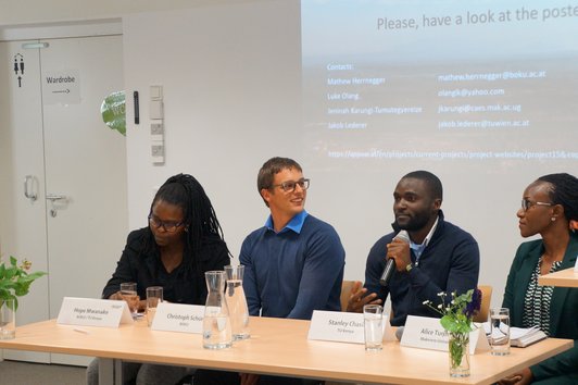 Four people sitting in front of their presentation talking about the project